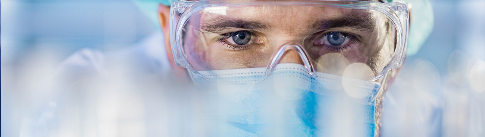 Close up of mid adult male scientist choosing test tubes while working in laboratory.